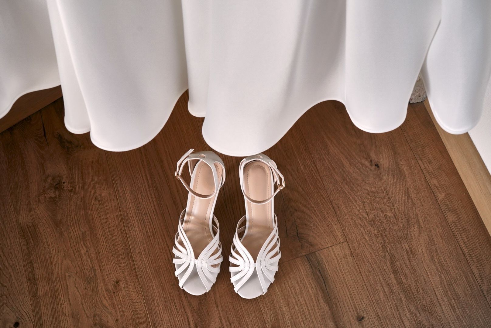 Sandali bianchi della sposa sotto l'orlo dell'abito